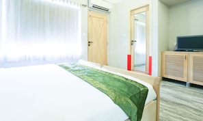 Habitació d'hotel amb un llit, una televisió i un armari.