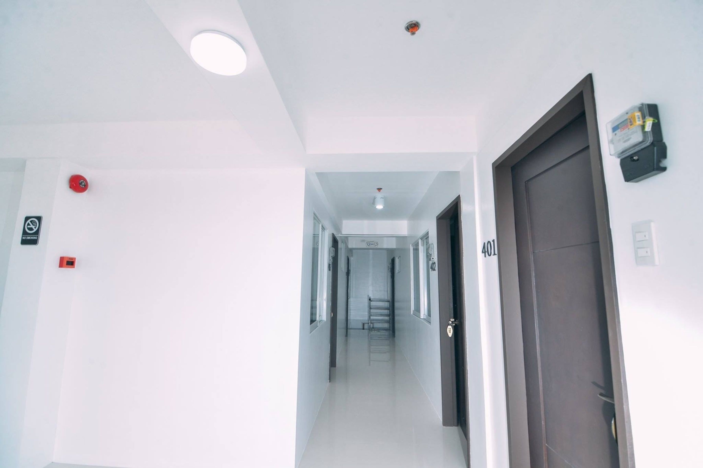 A clean, well-lit hallway with a fire alarm and a door marked 401.