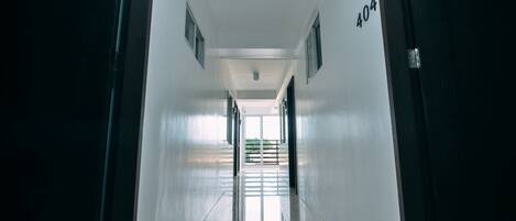 A long, narrow hallway with a reflective floor and a door marked with the number 404.