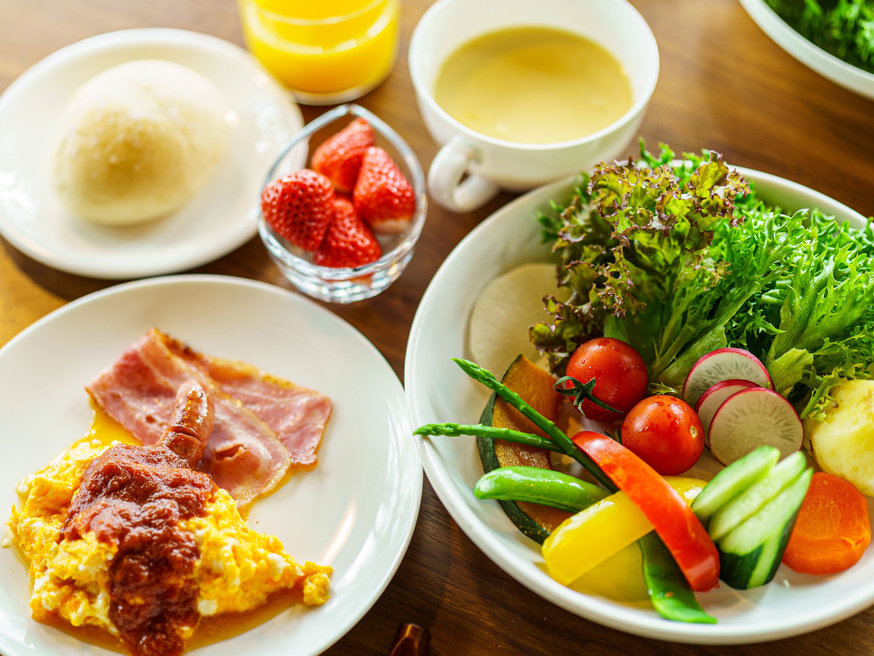Desayuno con huevos, tocino y una ensalada de frutas.