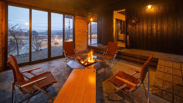 A cozy room with a fireplace, large windows, and a view of the outdoors.