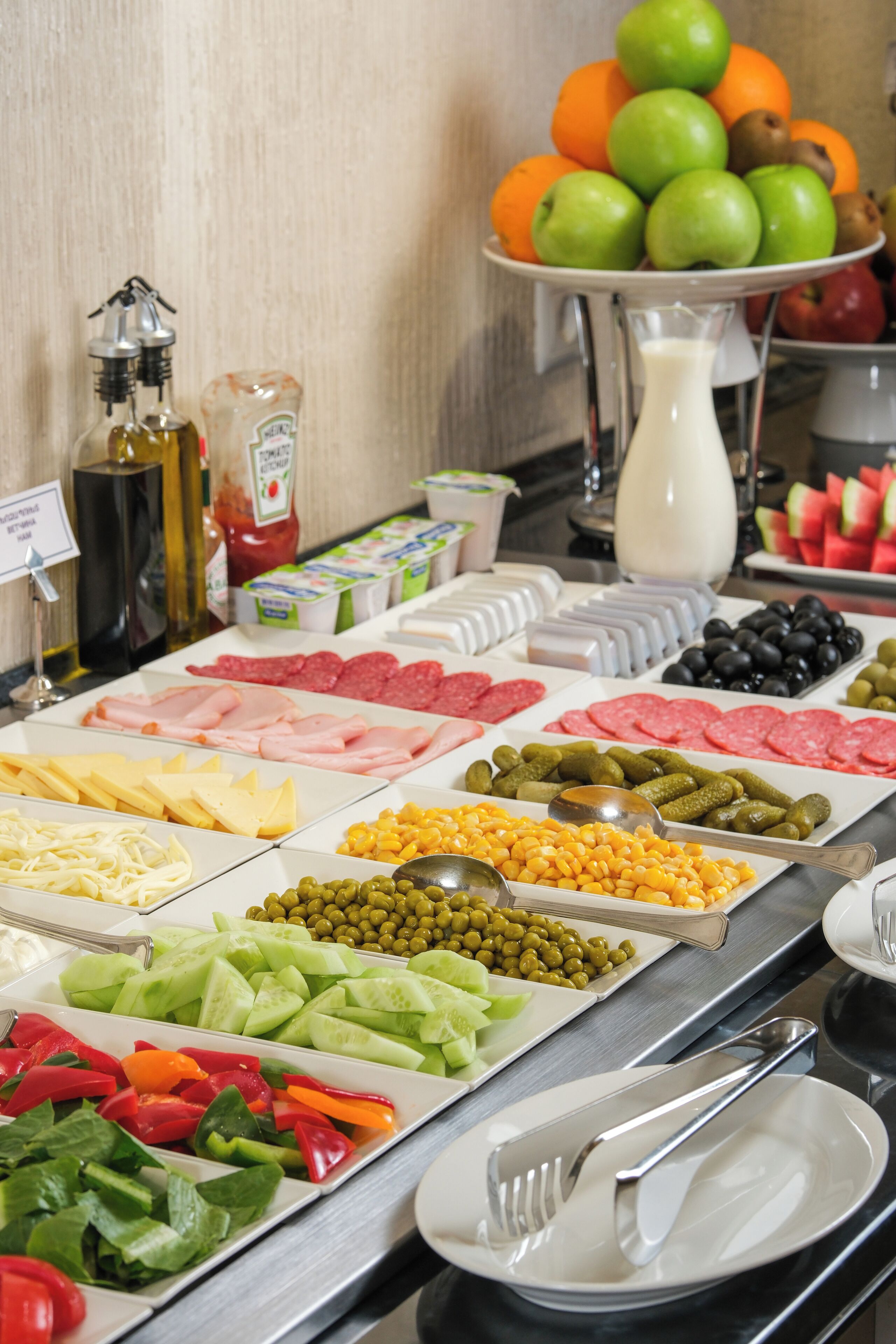 A buffet with various food items including meats, cheeses, fruits, and vegetables.