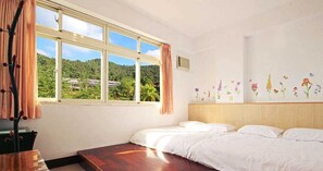 Un dormitorio con un ventanal grande, una cama y una pared decorada con motivos florales.