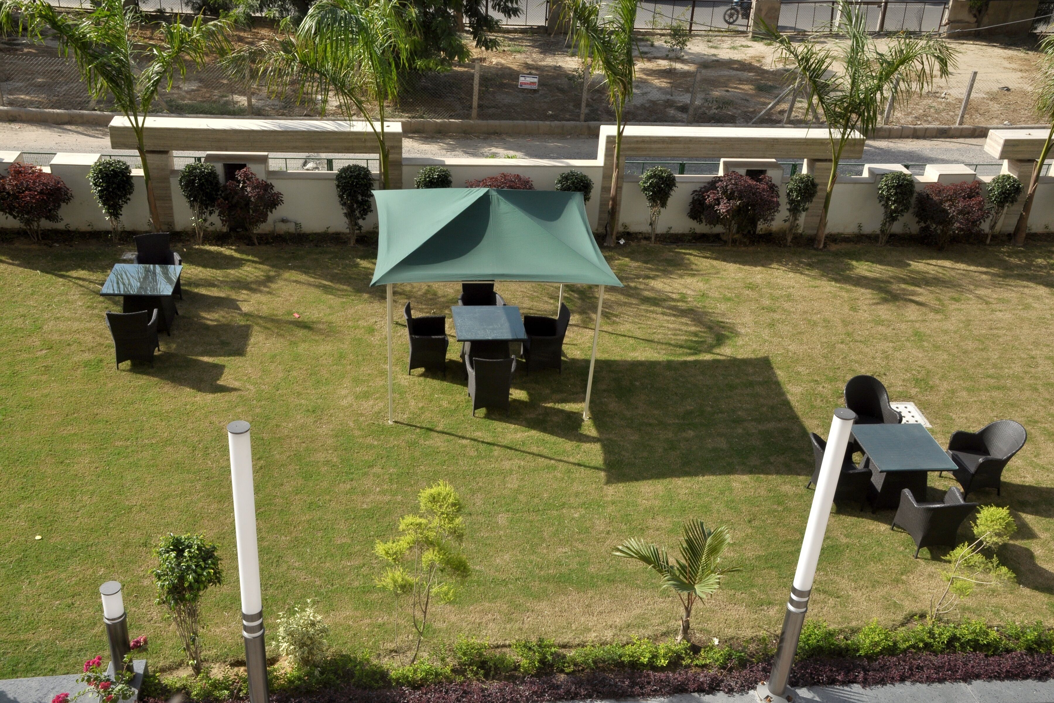 A patio area with a green canopy, outdoor seating, and small plants.