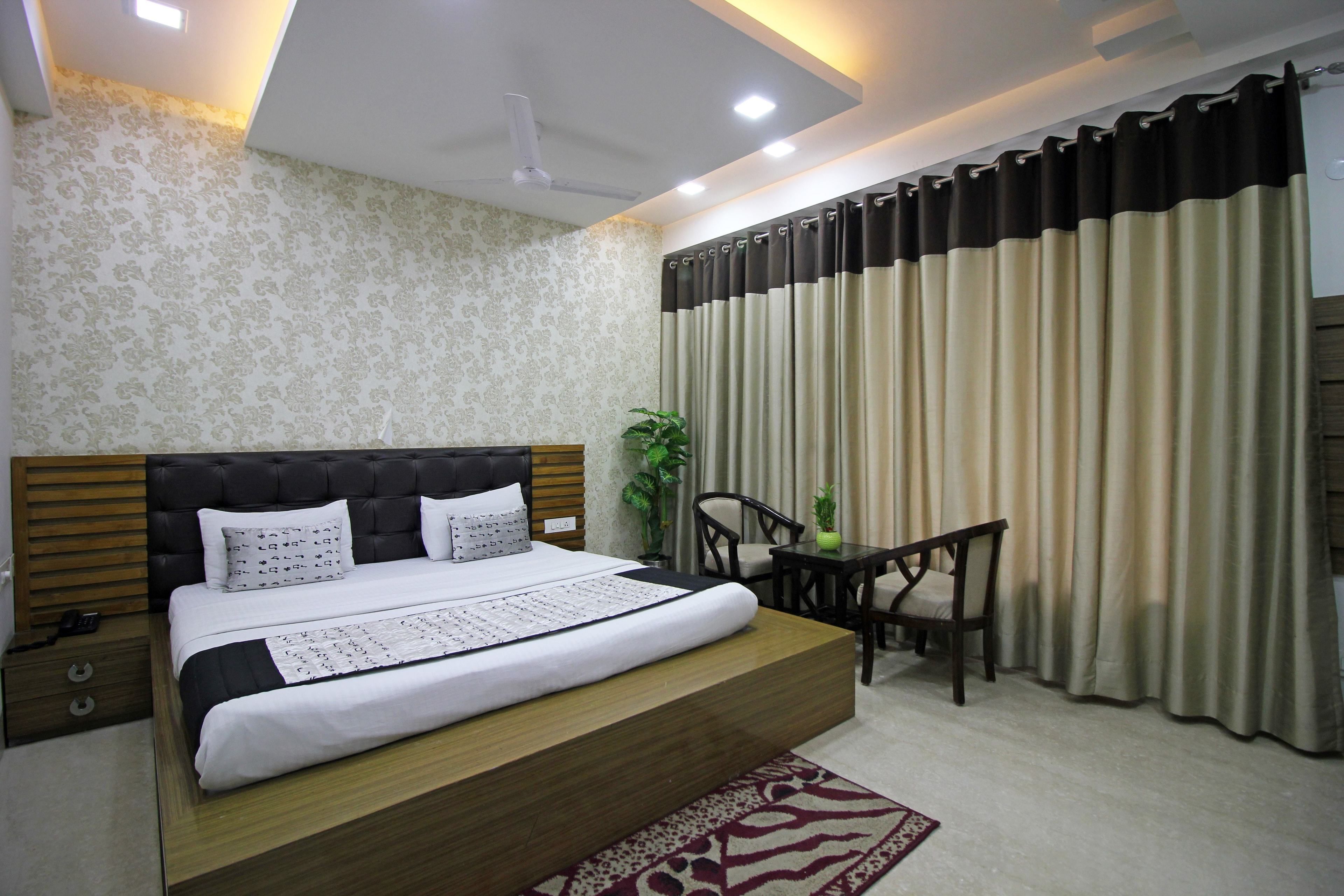 A modern bedroom with a large bed, a small table, and a chair.