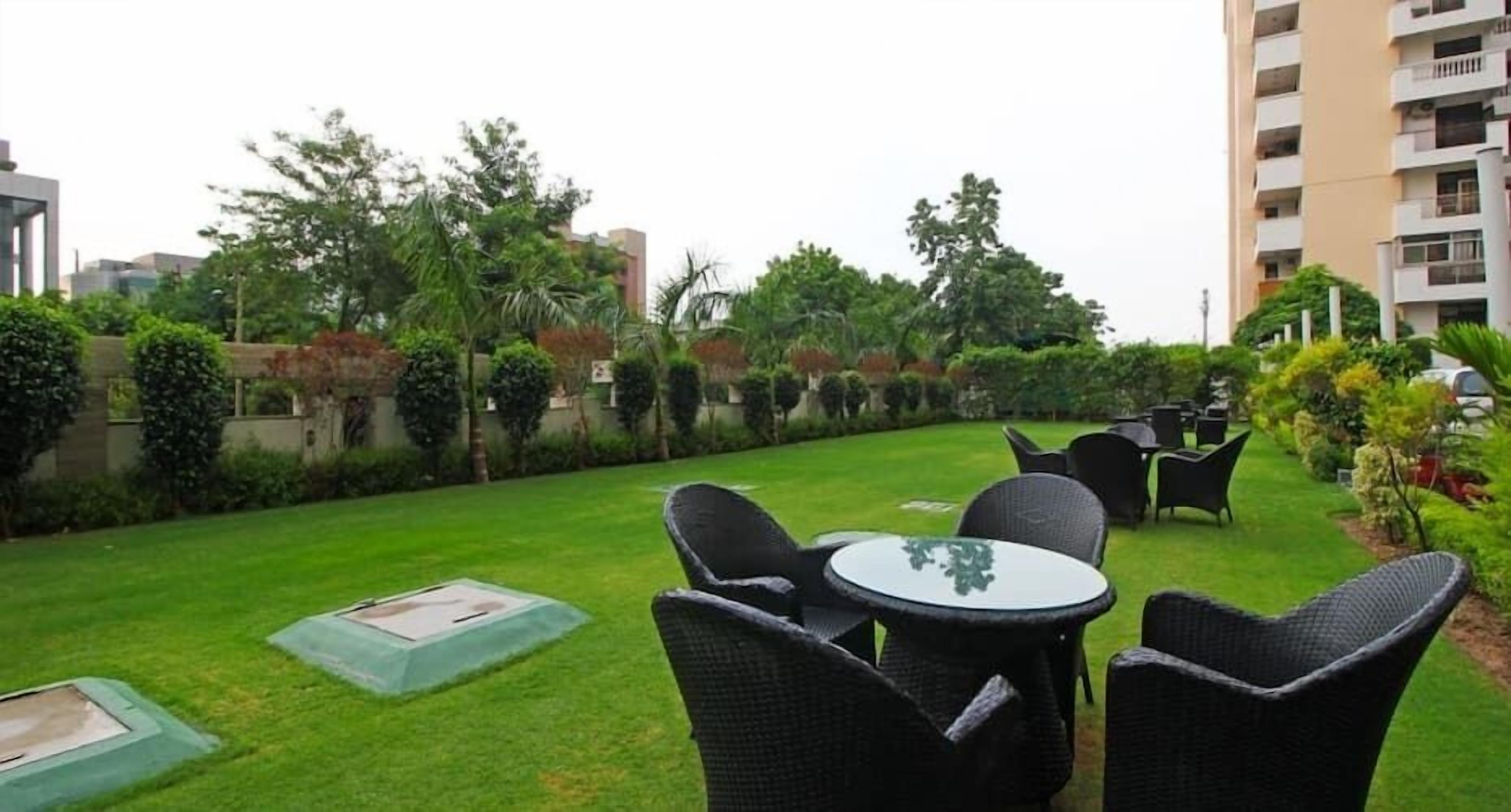 A courtyard with outdoor seating, a well-maintained lawn, and surrounding greenery.
