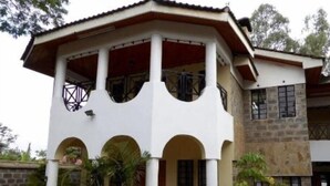 Un edificio de dos pisos con un atrio central, varios arcos y un porche cubierto.