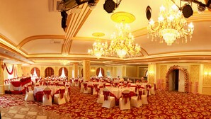 A large banquet hall with round tables, red and white tablecloths, and chandeliers. - Royal House Hotel 2 (Ulaanbaatar)