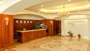 A lobby with a reception desk, a chandelier, and a sign for the Royal House Hotel. - Royal House Hotel 2 (Ulaanbaatar)