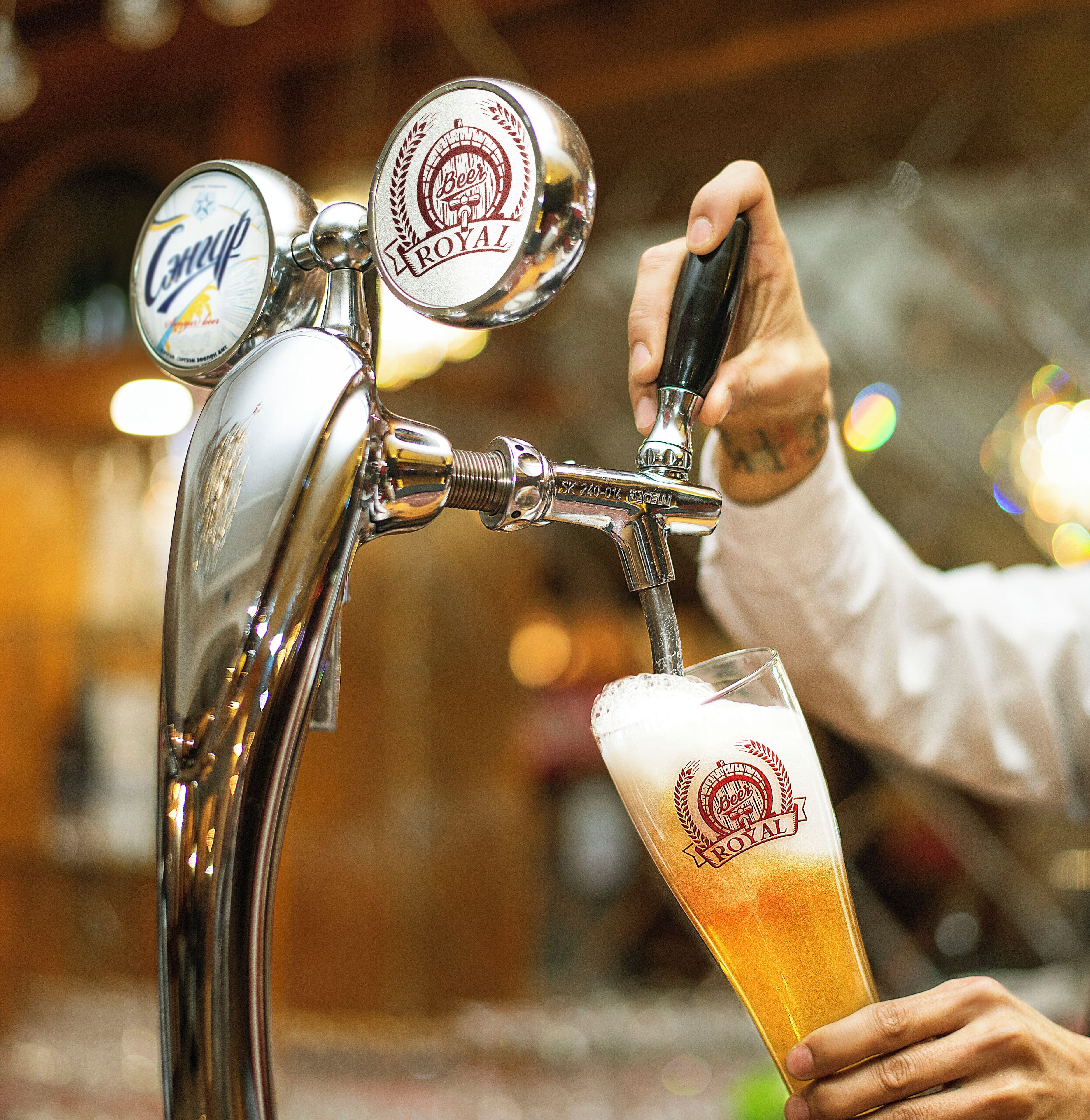 Un grifo con logotipo de cerveza y una jarra siendo llenada.