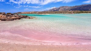 A beach with clear turquoise water, a pink sand foreground, and distant mountains under a blue sky. - Villa Sirocos, Private eco pool, near the beach (Chania)