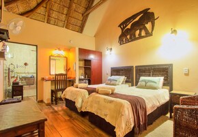 Una habitación con cama, escritorio, silla y baño.