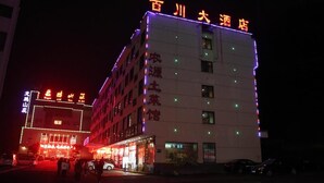 Un hotel con señalización iluminada, varios pisos y una entrada visible.