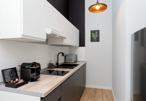 Una cocina moderna con cafetera espresso integrada, tostadora y encimera negra.