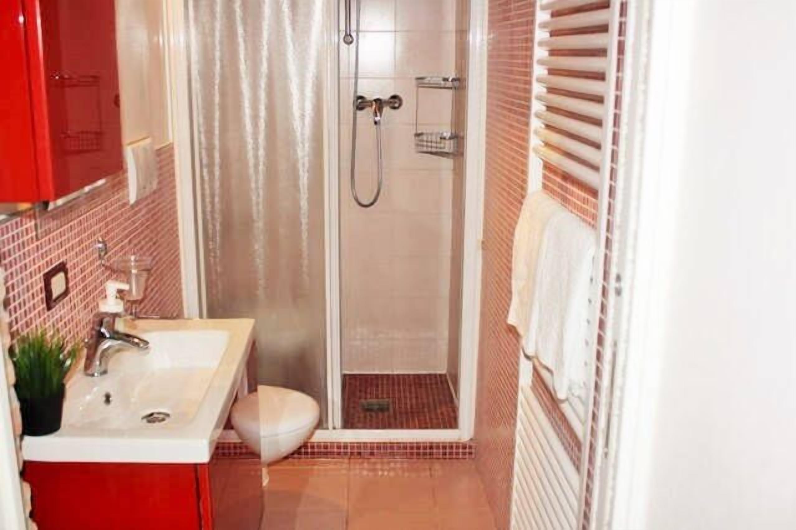 Une salle de bain avec douche, toilettes et lavabo.