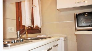 A kitchen with a microwave, sink, and cabinets. - Mario Apartment 3028 F (Venice)