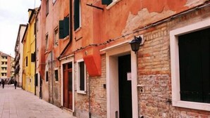 A narrow street lined with historic buildings, featuring a mix of brick and plaster facades, some with visible wear and tear. - Mario Apartment 3028 F (Venice)