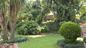 Un jardin bien entretenu, avec une grande variété de plantes et une pelouse soigneusement taillée.
