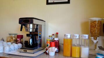 Un comptoir de cuisine avec une machine à café, divers aliments et des condiments.