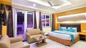 A hotel room with a bed, sofa, and a glass coffee table. - Hari Piorko Inn Express (New Delhi)