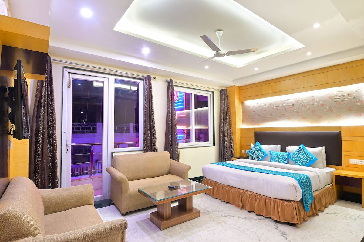 A hotel room with a bed, sofa, and a glass coffee table.