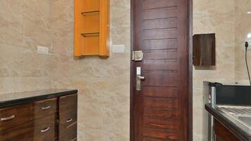Un baño con puerta y mueble de madera, y pared de mármol.