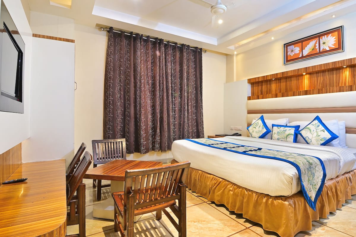 A hotel room with a bed, a desk, and a chair.