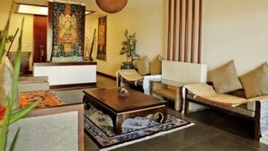 Un vestíbulo moderno con un sofá, sillones, una mesa de centro y una lámpara colgante.
