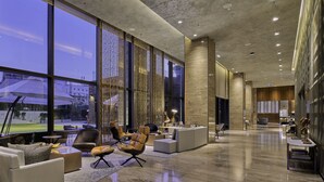 Eine geräumige Lobby mit großen Fenstern, modernen Möbeln und einem sauberen, glänzenden Boden.