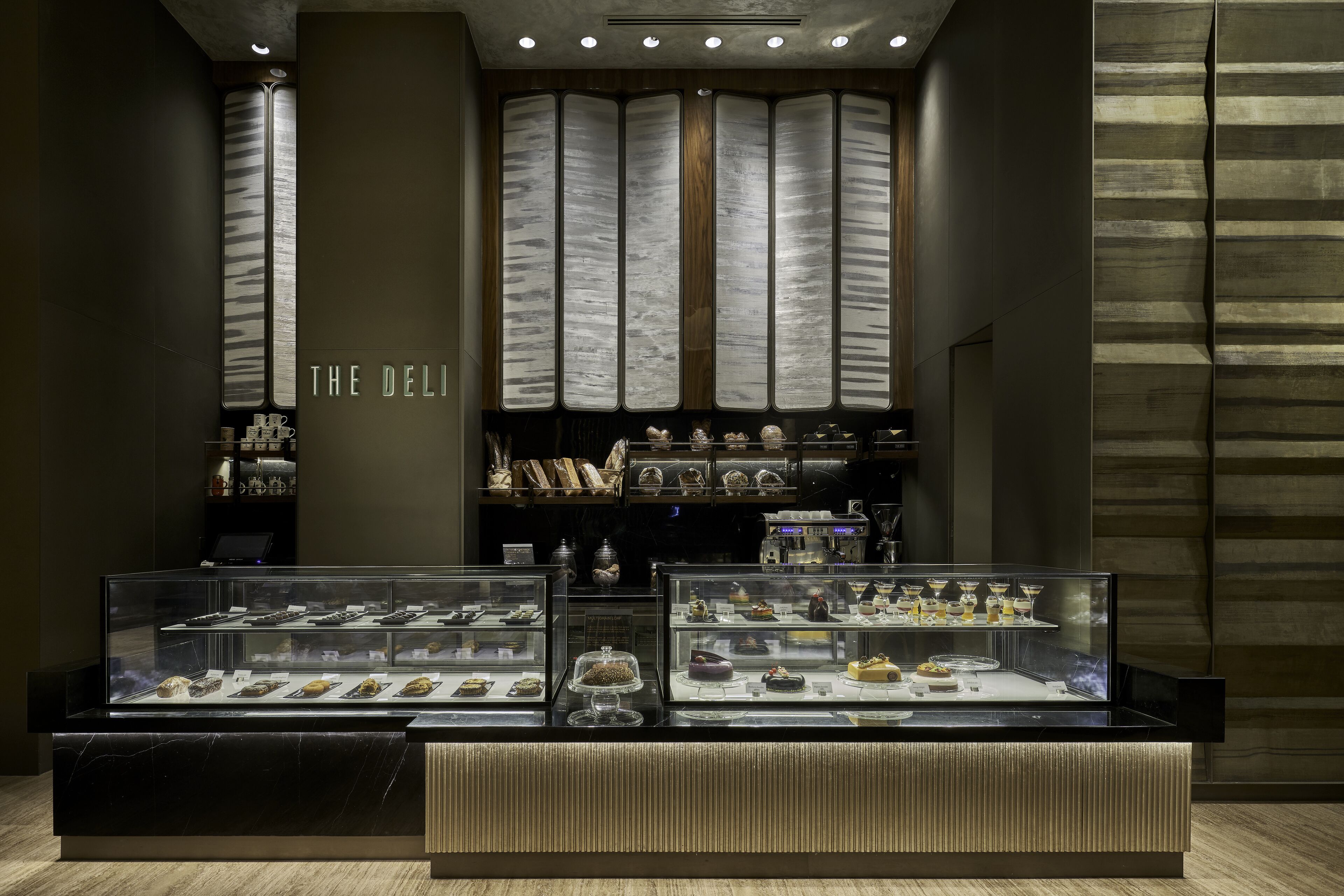 A dessert display case in a hotel lobby with a sign reading "THE DELI".