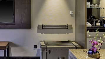 A modern bathroom with a large mirror, a towel rack, and a sink with a marble countertop.