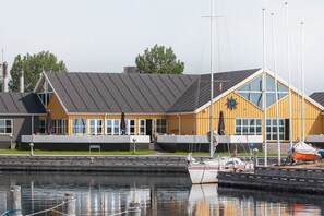 A waterfront building with a sloped roof, large windows, and a flagpole. - Kaløvig Badehotel (Aarhus)