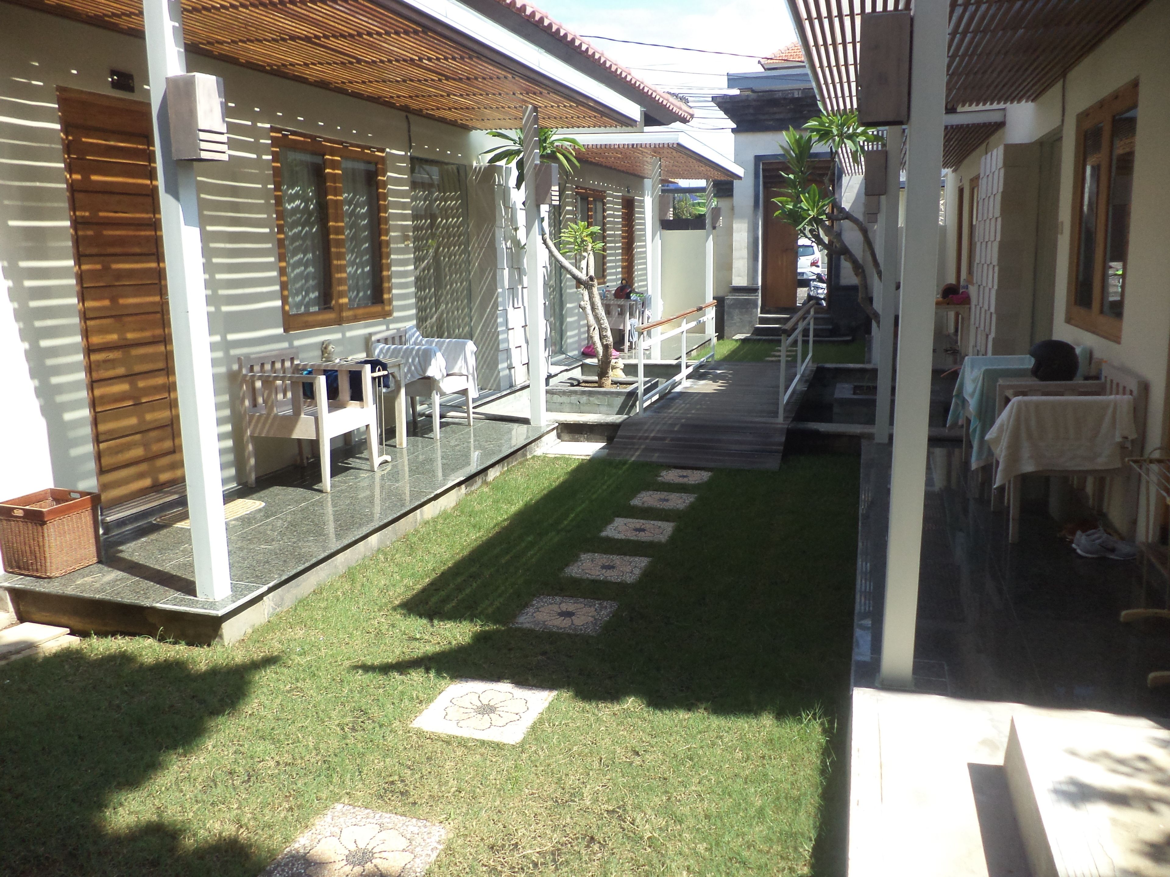 Un espacio al aire libre cubierto con un patio, asientos y un pequeño jardín.