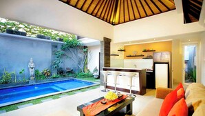 A modern living room with a pool, a dining area, and a kitchen. - Intan Legian Seminyak Villa (Denpasar)