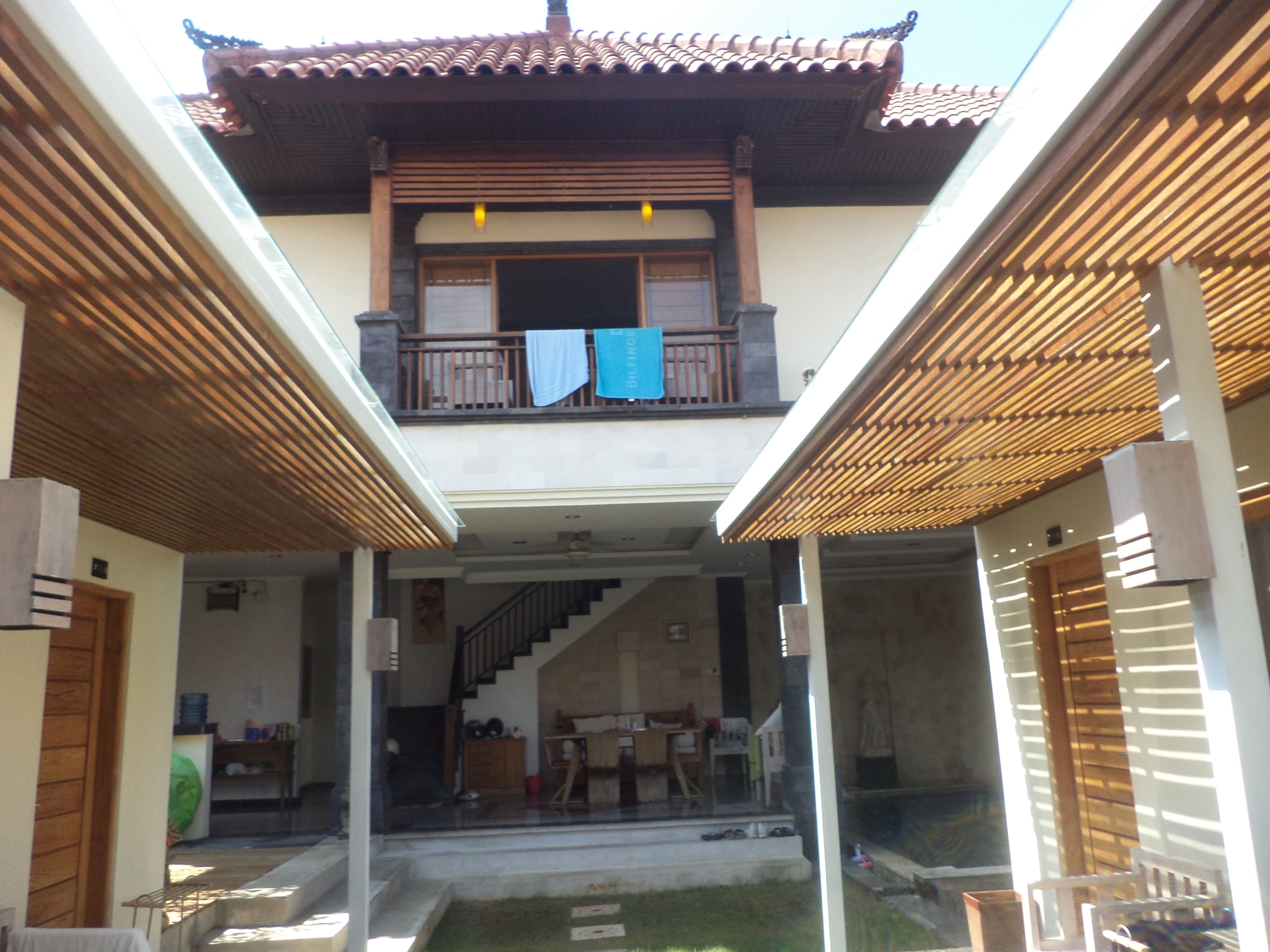 A traditional building with a balcony, wooden beams, and a staircase leading to an upper level.