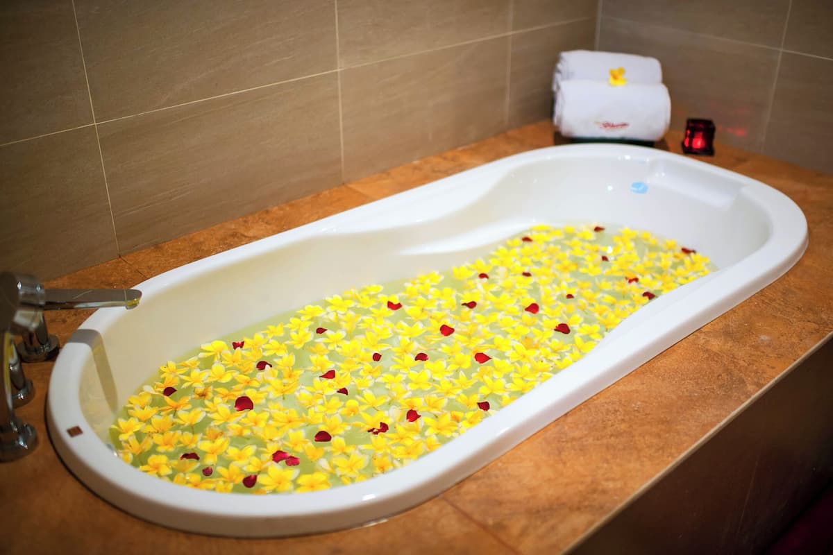 Una bañera llena de flores amarillas y rojas.