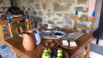 A table set with a pitcher, plates, bowls, and a bowl of fruit.
