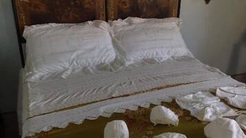 Un lit avec du linge de lit blanc et une couvre-lit à motifs floraux.