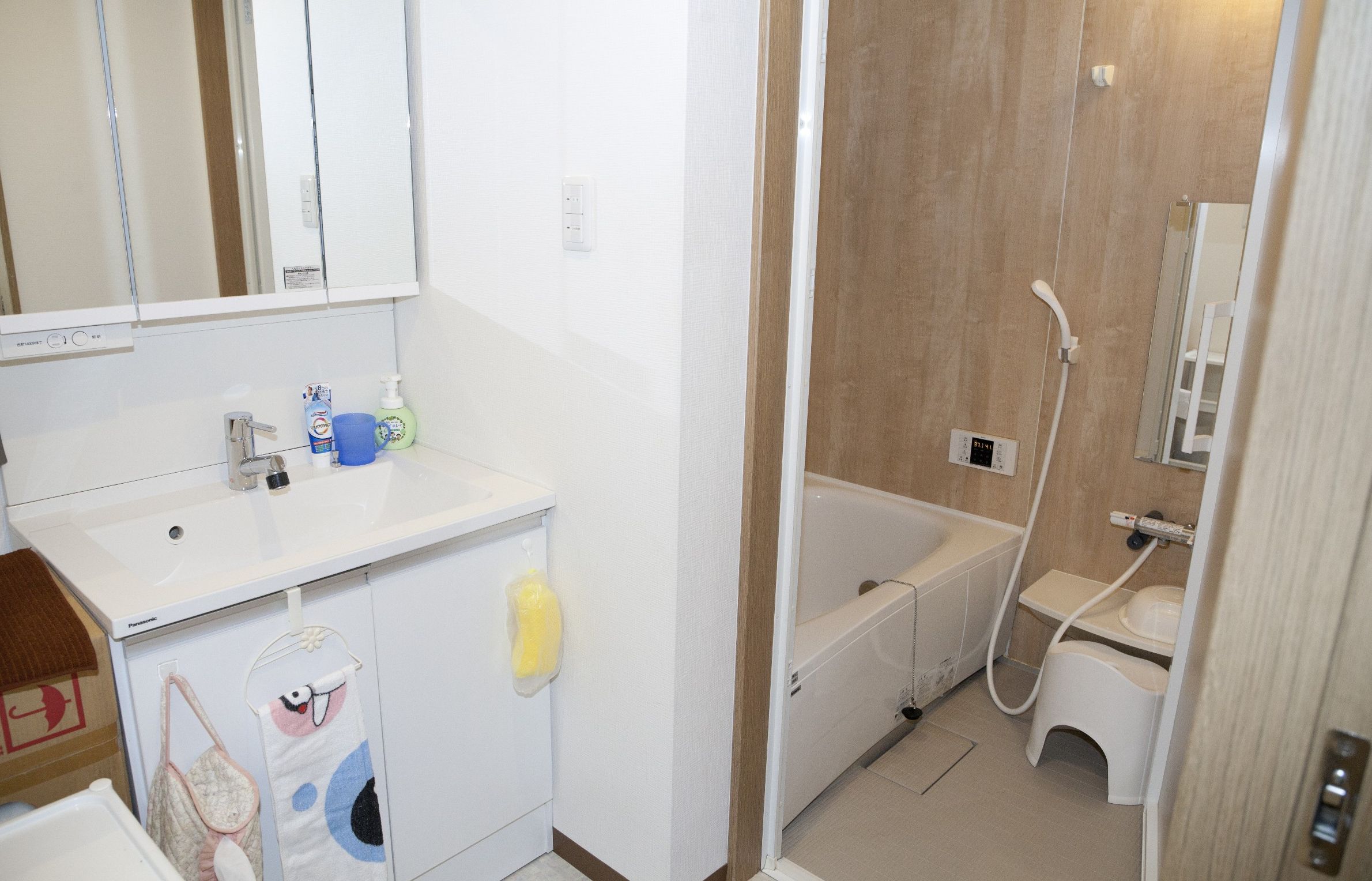 A bathroom with a sink, mirror, and a shower area.