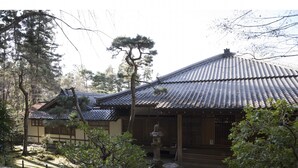 A traditional Japanese building with tiled roofs, a stone courtyard, and a stone lantern. - Guest House Aoi Nakamoto (Kyoto)