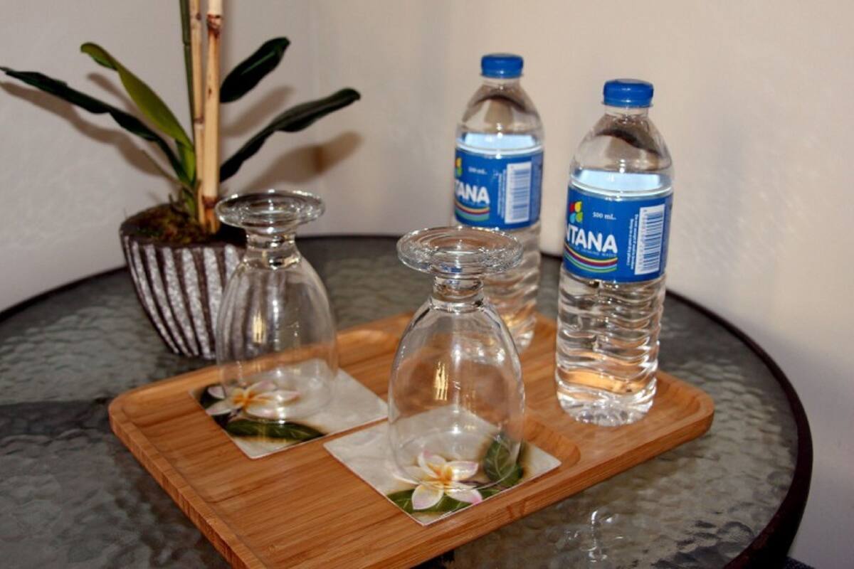 A tray with two glass bottles of water and two glass decanters on a table.