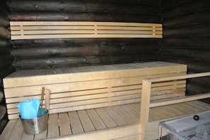 Relax in a serene sauna with a wooden bench and towels at hand.