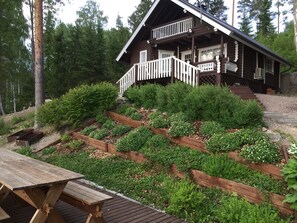 Escape to a serene cabin surrounded by lush gardens and a wooded landscape.