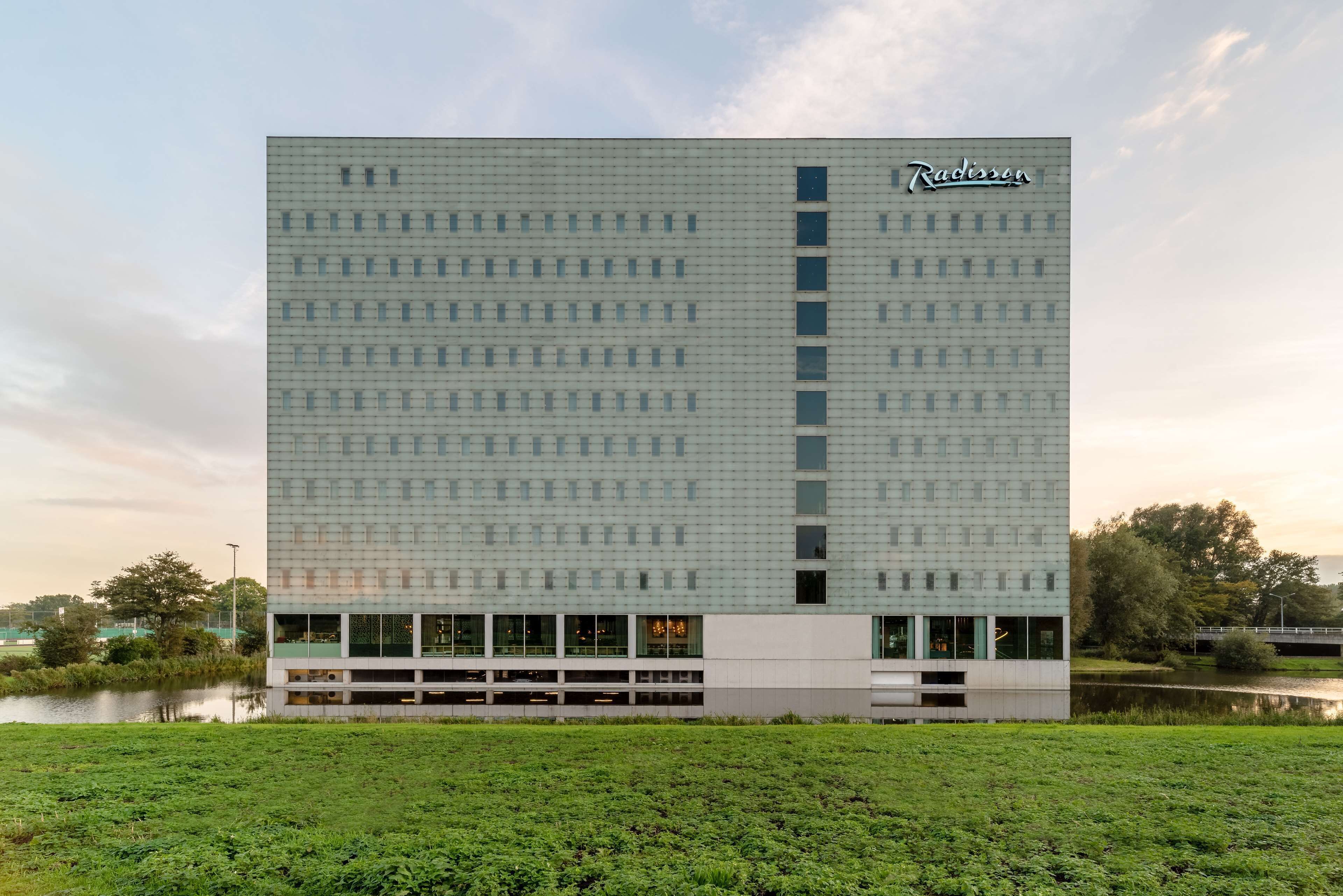 Un hotel Radisson moderno con fachada de diseño geométrico, una banda vertical central y techo plano.
