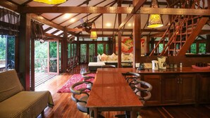 A spacious wooden interior with a long dining table, comfortable seating, and a staircase. - 7 Bedroom Sea Front Villa Koh Phangan SDV232-By Samui Dream Villas (Ko Pha-ngan)