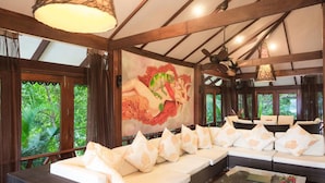 A room with a long sofa, a coffee table, and a mural on the wall. - 7 Bedroom Sea Front Villa Koh Phangan SDV232-By Samui Dream Villas (Ko Pha-ngan)