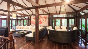 A spacious room with a high ceiling, wooden beams, a large sofa set, a round dining table, and a painting on the wall. - 7 Bedroom Sea Front Villa Koh Phangan SDV232-By Samui Dream Villas (Ko Pha-ngan)