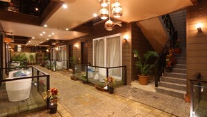 A spacious lobby with a glass railing, potted plants, and a staircase. - Sinon Baga Retreat (Baga)