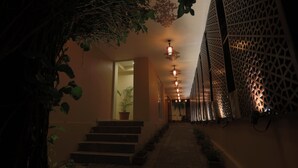 A dimly lit hallway with a staircase, decorative lighting, and a lattice wall. - Sinon Baga Retreat (Baga)