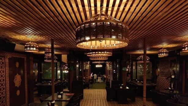 A restaurant with a wooden ceiling and tables with candles. - Sinon Baga Retreat (Baga)